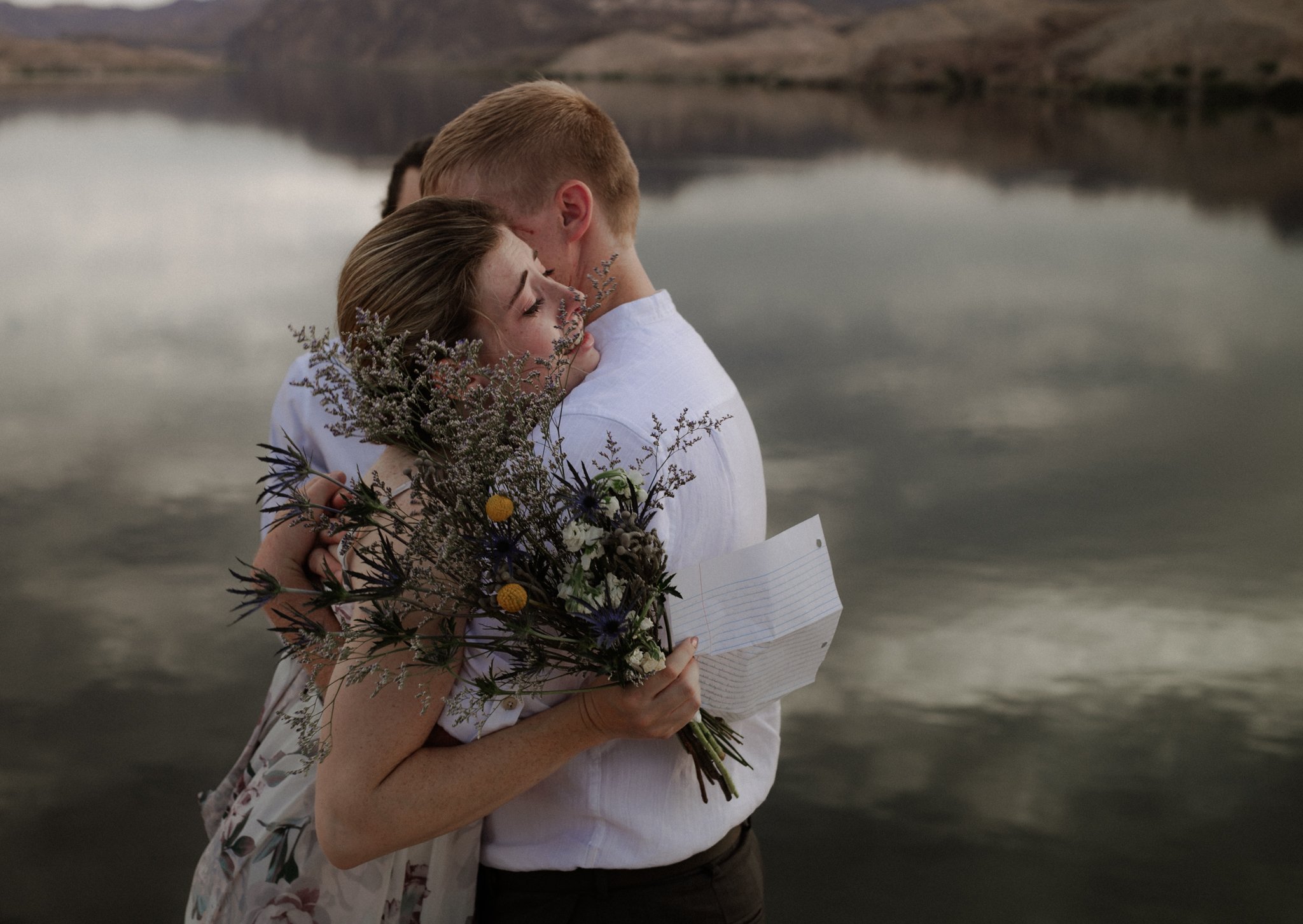 Groom holds bride as she cries over looking Colorado River