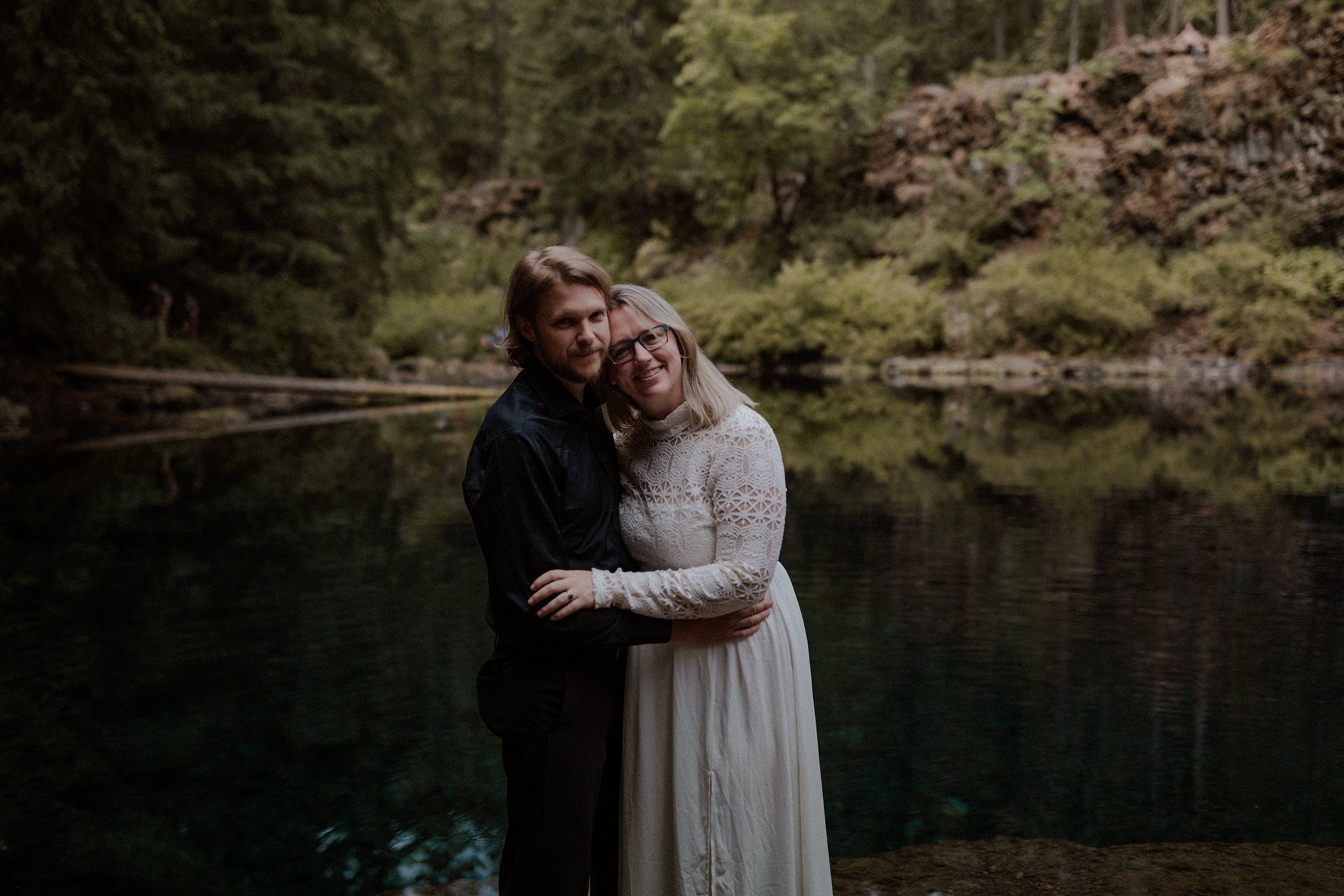 Wedding couple standing by the Blue Pool in Oregon for their portraits