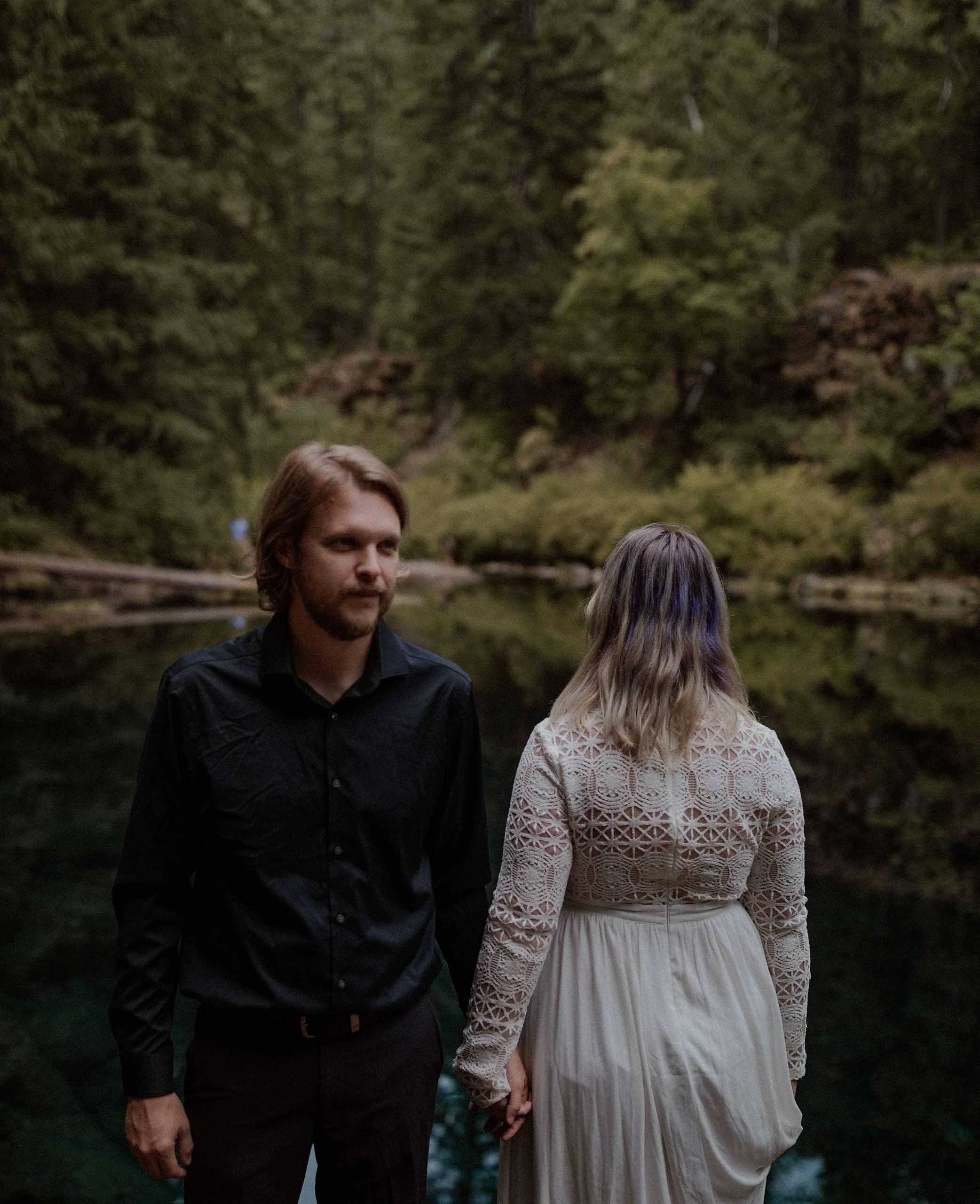Wedding couple standing by the Blue Pool in Oregon for their portraits