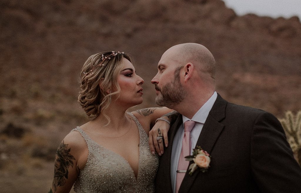 Bride and groom caress in the desert at sunset Las Vegas Elopement Photographer