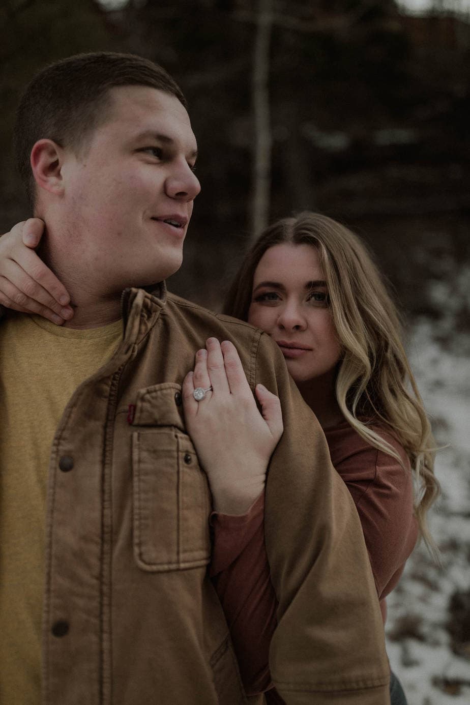 Girl wraps around her fiance in the forest during their Oregon adventure engagement session. Her big engagement ring steals the show