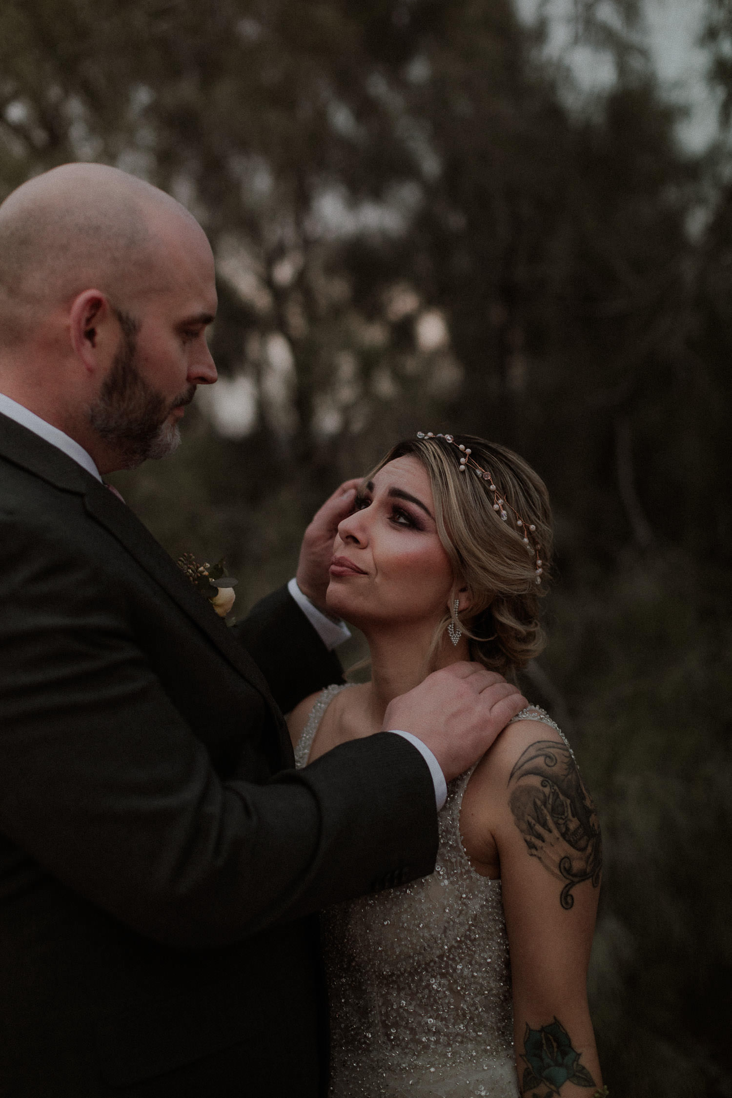 Brides tries to hold back tears as her new husband looks into her eyes and touches her cheek. This intimate forest elopement was so emotional and perfect for the couple