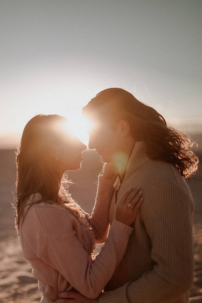 Romantic outdoor couples session right at sunset with sun flares and golden light