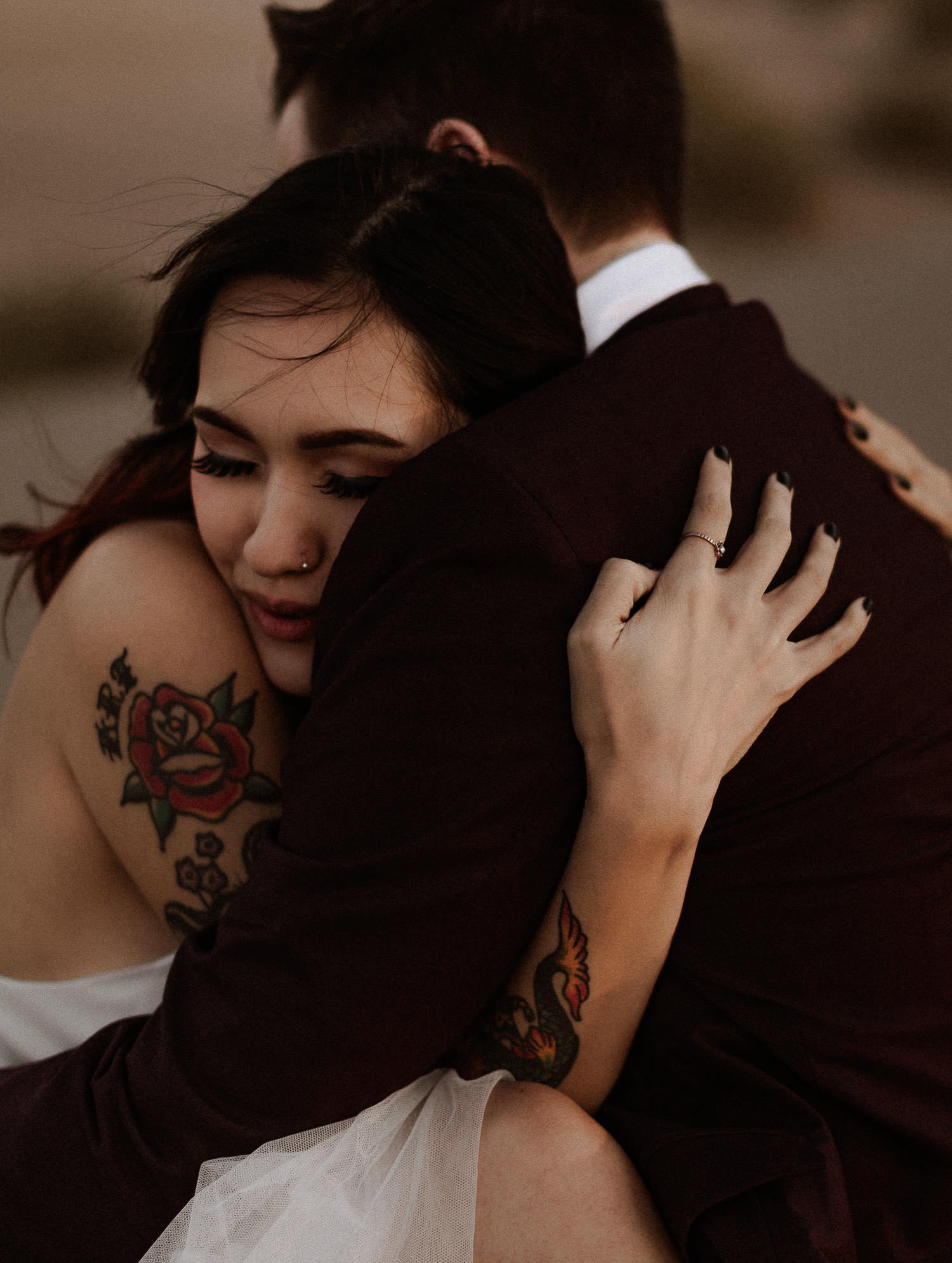 Bride hugs her groom tightly to stay warm from the wind in the desert. Oregon elopements can get a bit chilly with the wind at sunset