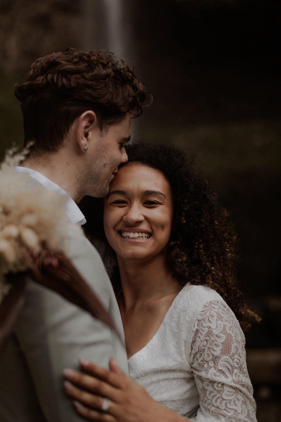 Bride smiles at the camera while her new husband kisses her forehead. This stress free elopement at Latourell Falls was so fun and easy to get to