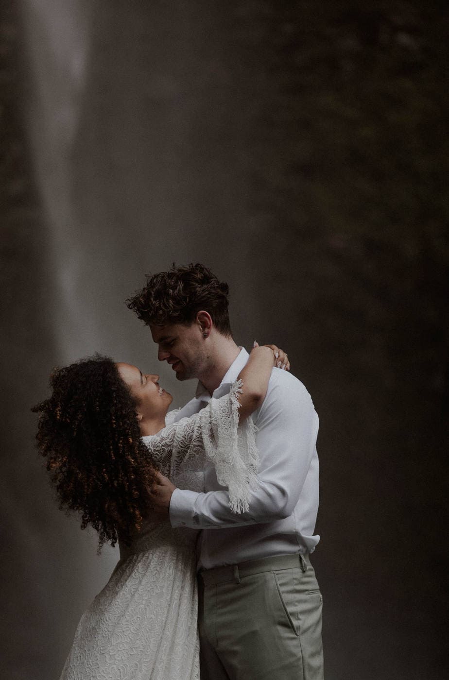 Wedding couple hold each other and snuggle close under Latourell Falls