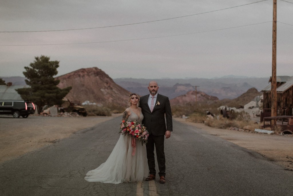 Wedding couple stands in the road in desert elopement