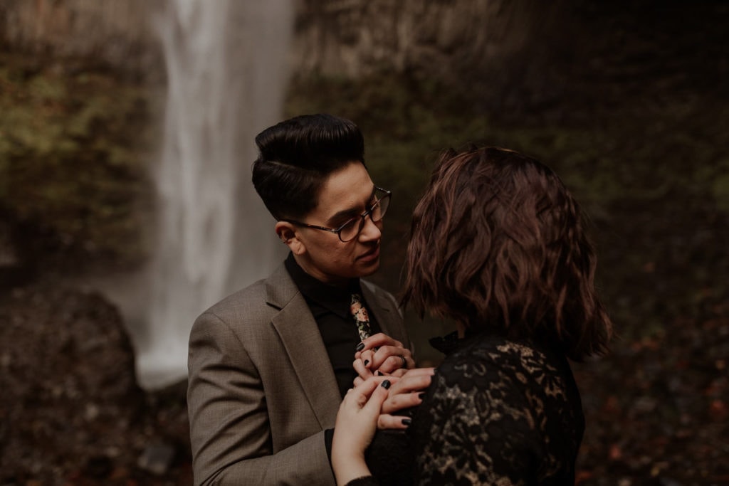 Newly engaged couple looks into each others eyes in front of  Latourell falls