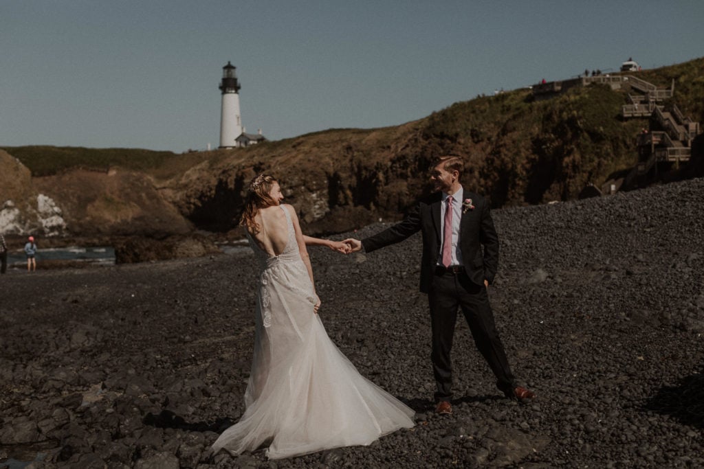 Bride and groom dance on Cobble beach for their elopement by Yaquina Head lighthouse