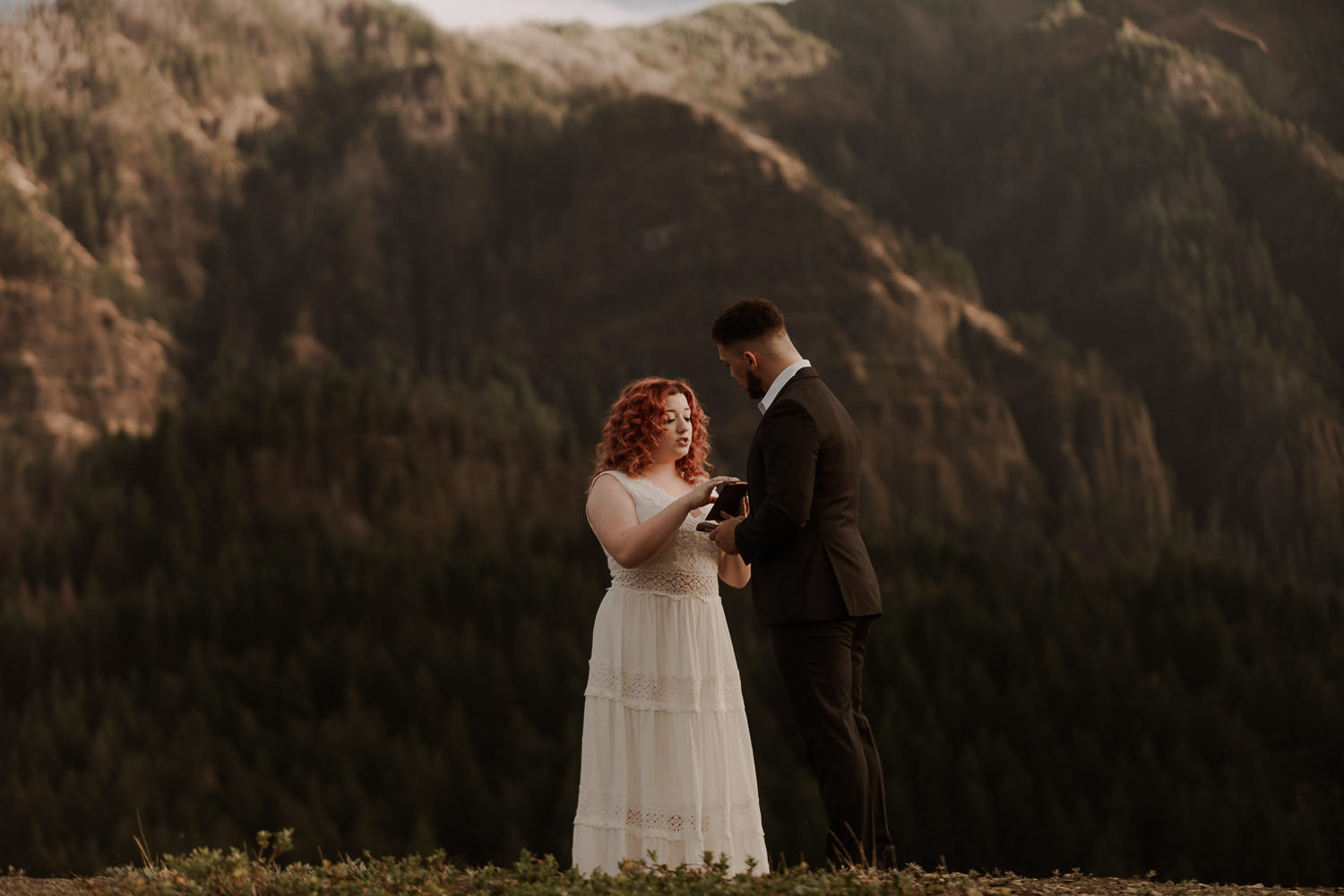 Eloping couple reads their vows together on top of a cliff in the Columbia River Gorge