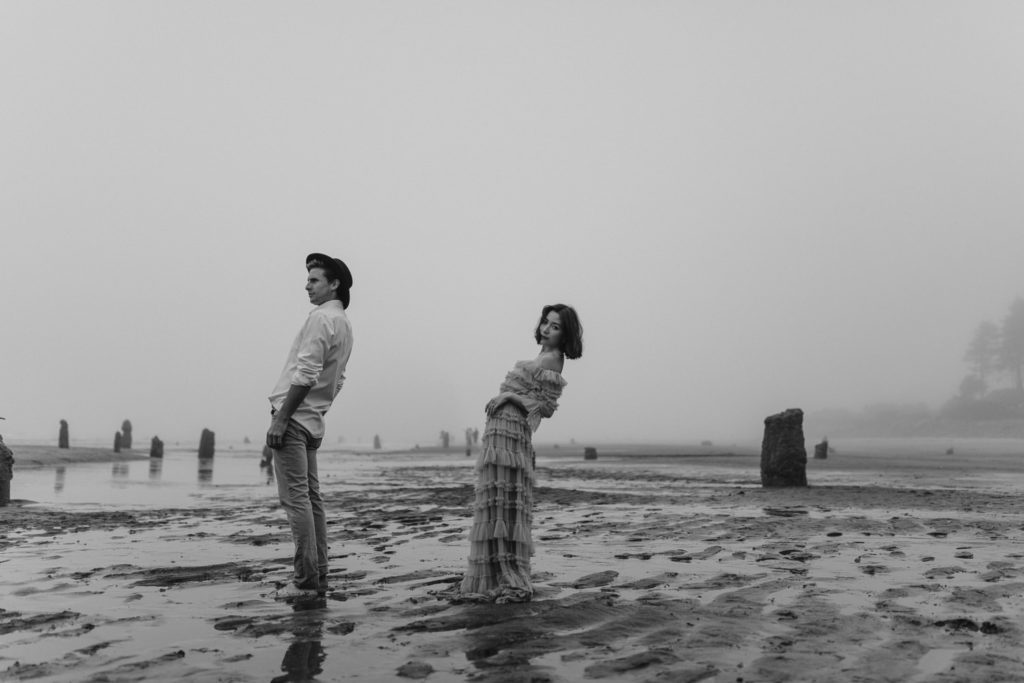 Black and white image of eloping couple posing on the beach