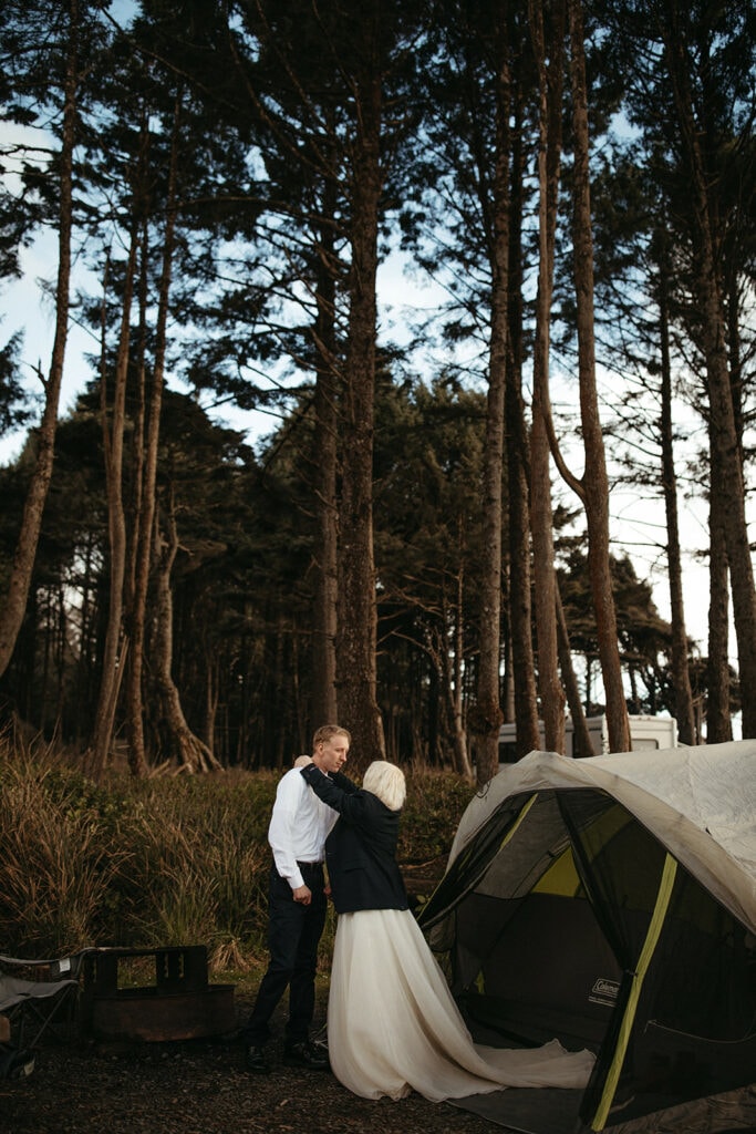 bride and groom getting ready in front of tent 