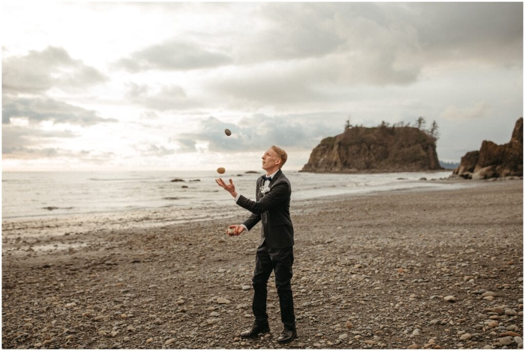 groom juggling rocks on the coast of Washington before his elopement