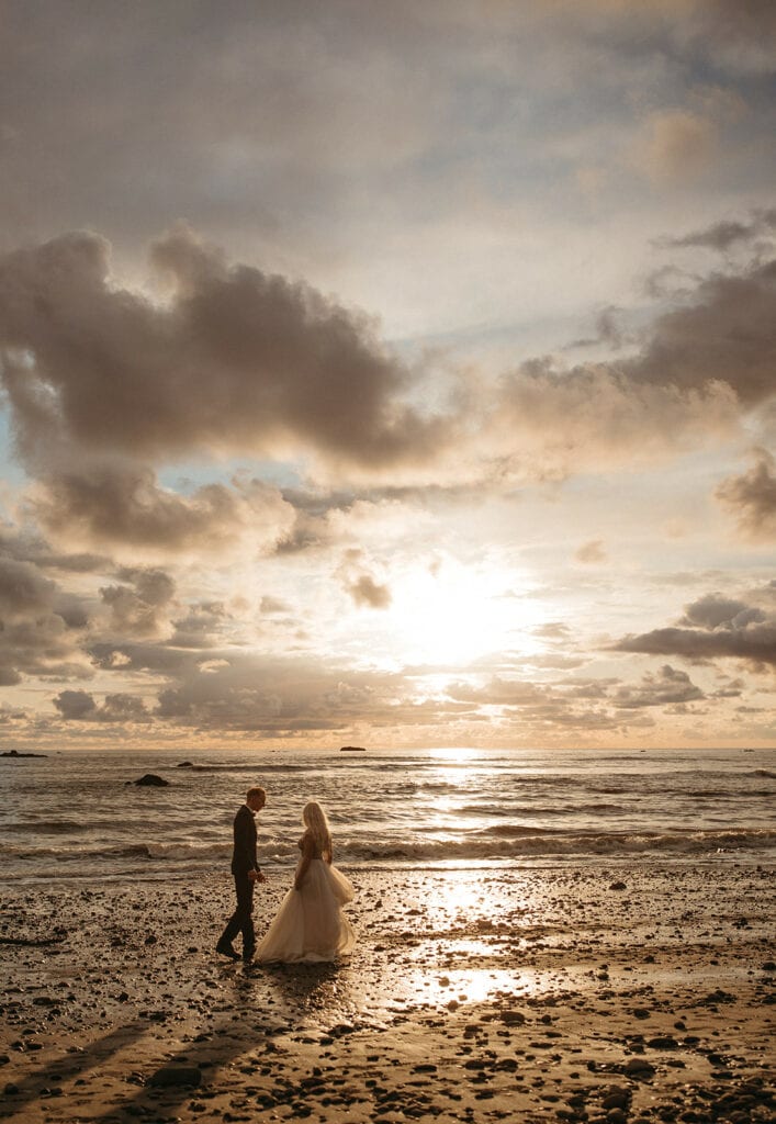 Bride and groom standing at the beach during sunset at  Ruby Beach in Washington state