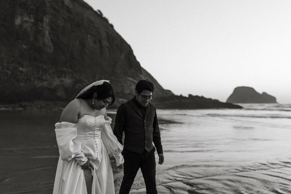 bride and groom walking along the beach during golden hour