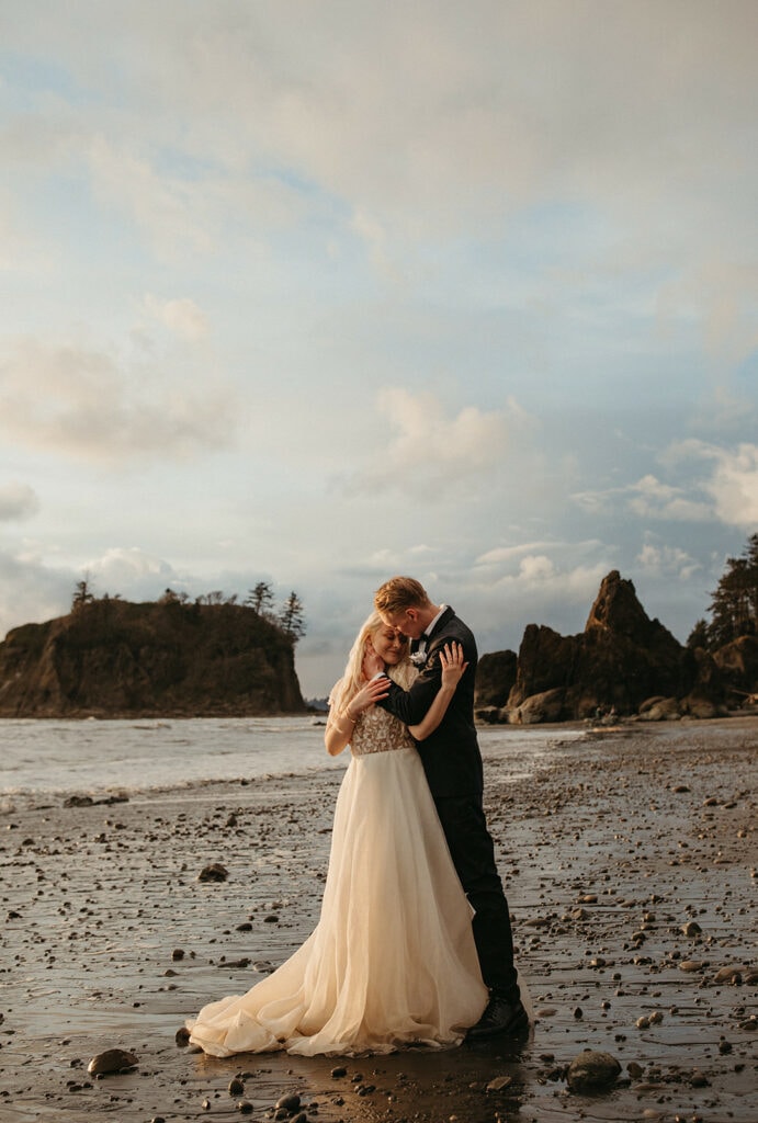 man and woman standing closely on the beach during their elopement portraits