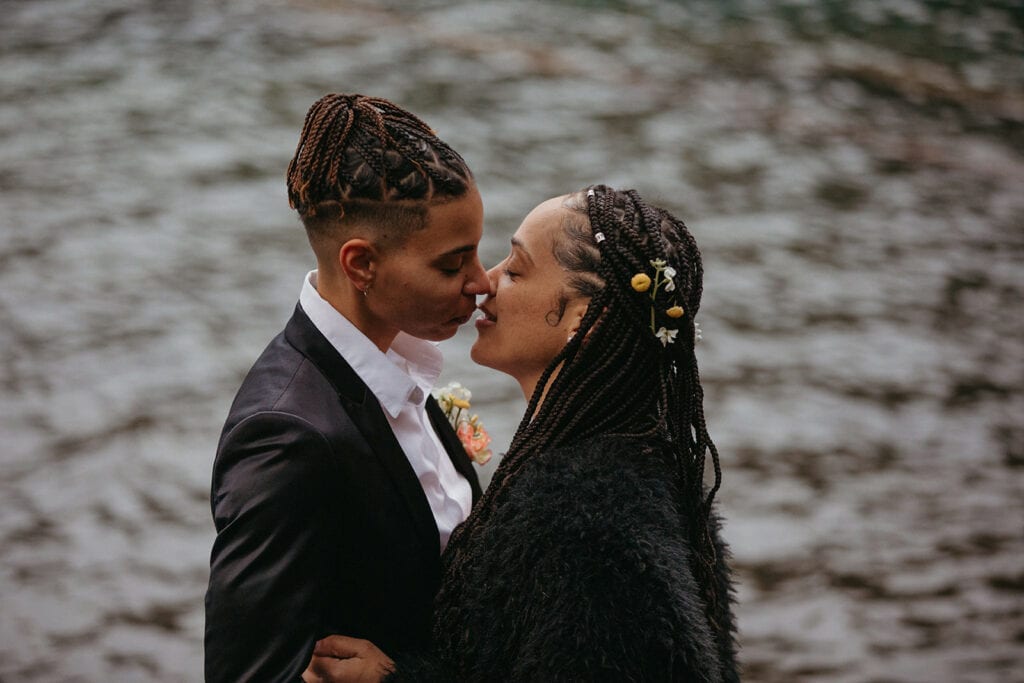 close up of brides almost kissing with water in the background 