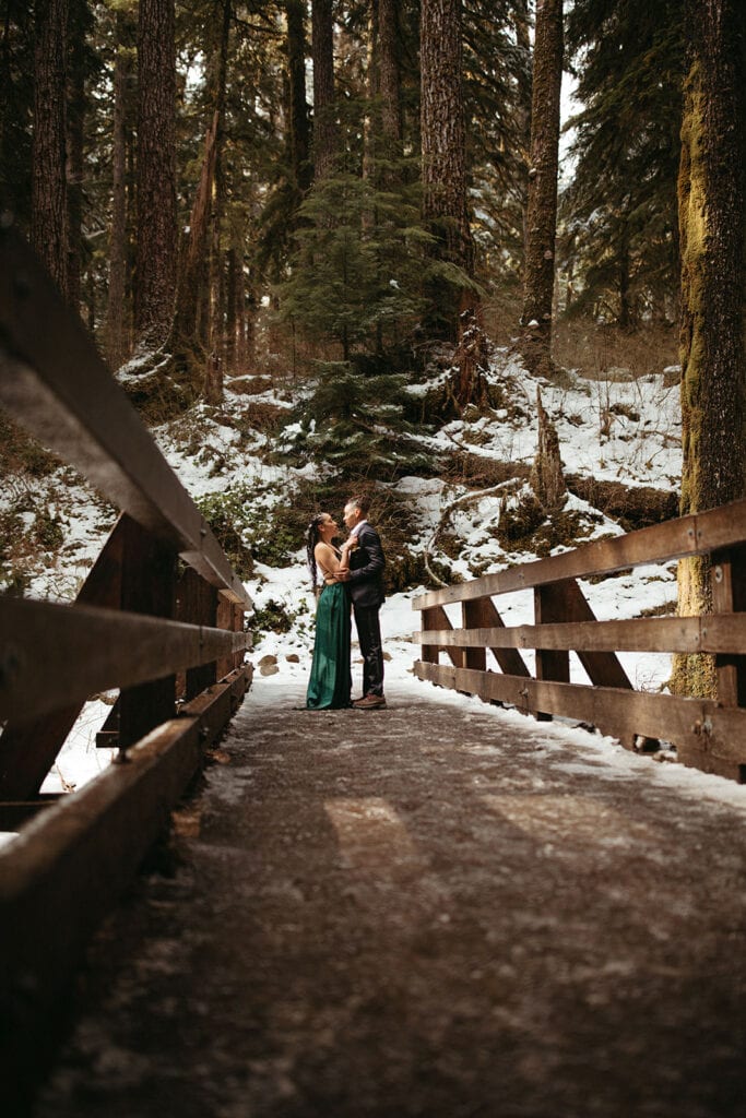bride and bride holding and staring at eachother at Sol Duc Falls