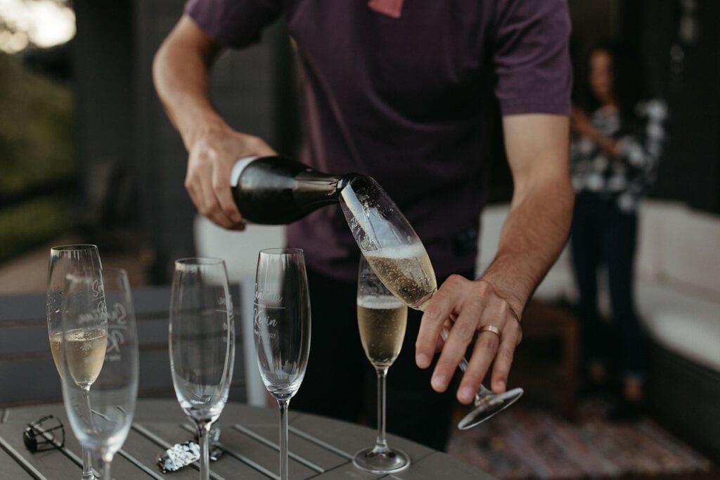 man pouring glasses of champagne