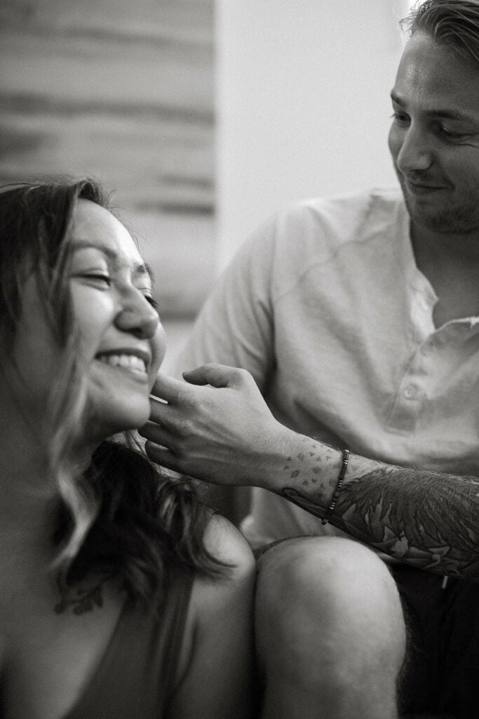 groom touching brides face smiling black and white shot 