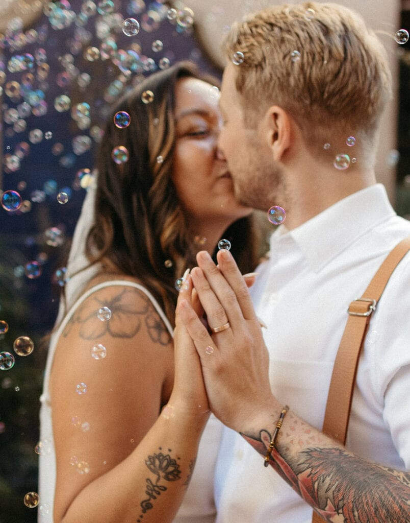 bride and groom share a kiss with bubbles around them at Santa Barbara close up photo 
