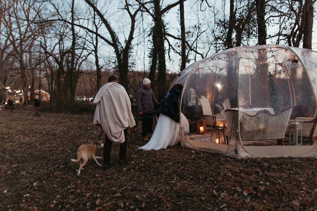 Jessi and Nate, sharing a sweet moment inside an igloo bubble tent surrounded by Christmas lights.