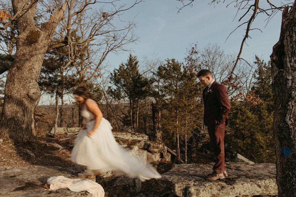 bride and groom leaping over a crack in the rocks