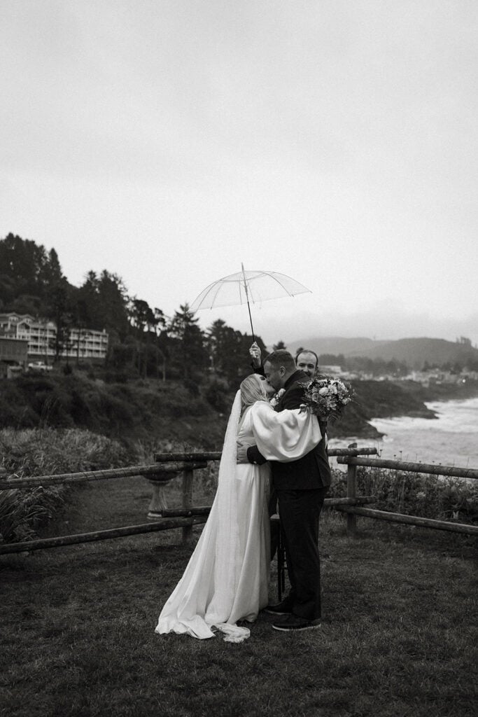 bride and groom first kiss after moody elopement ceremony on the Oregon Coast