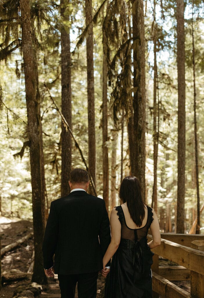 couple walking down a wooden staircase in the forest
