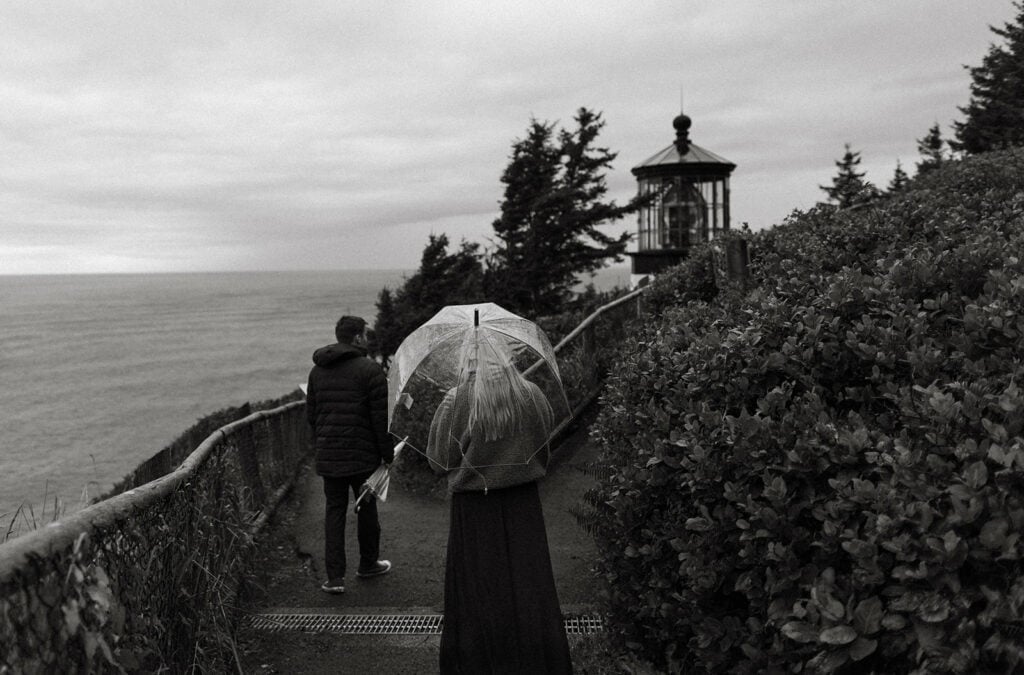 bride and groom walking to a lighthouse on the Oregon Coast