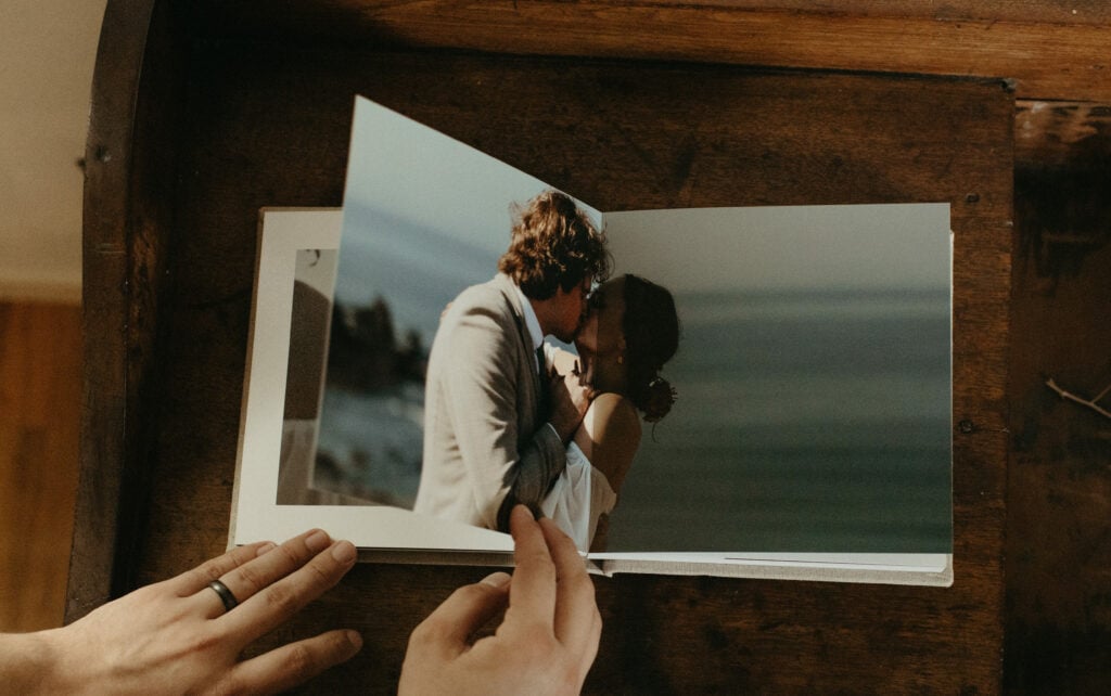 PNW elopement photographer flips through a wedding album