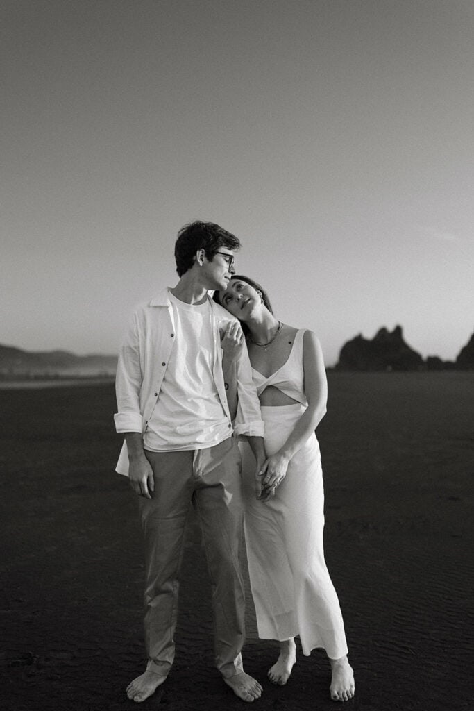 Couple lovingly stands on the beach in Oregon