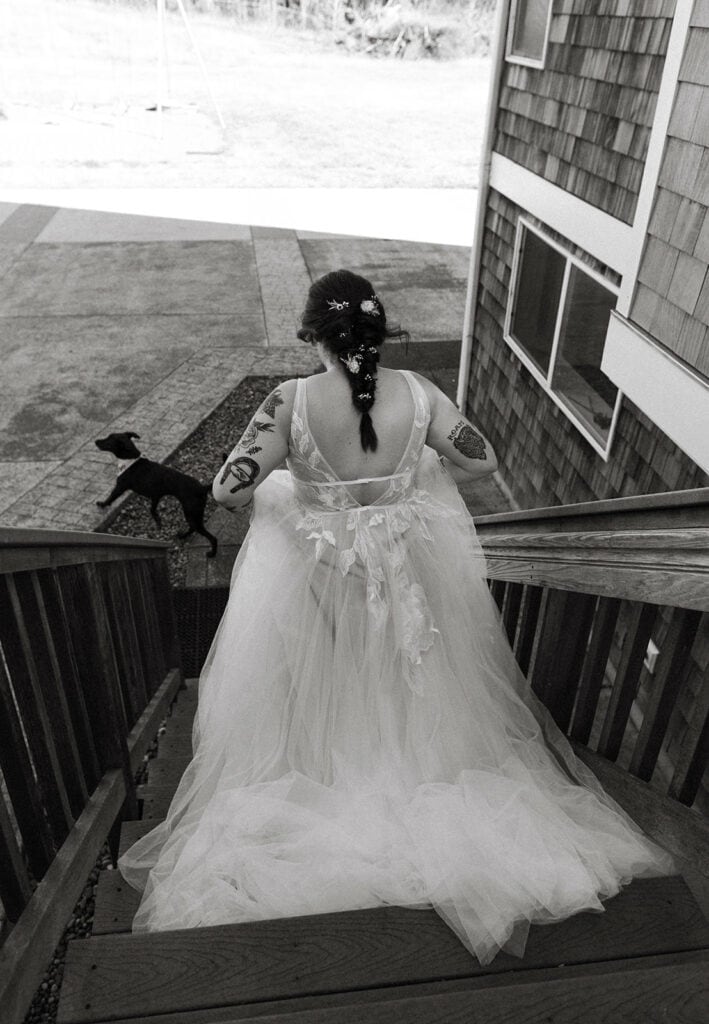 Bride walking down a wooden staircase to her first look with the groom