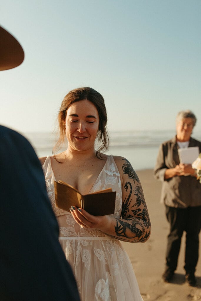 Bride reads vows during sunset beach ceremony