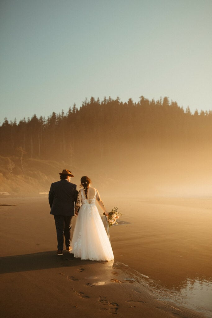 Bride and groom walking on an Oregon Coast beach