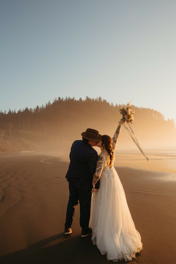 Bride and groom kiss at sunset on the Oregon Coast