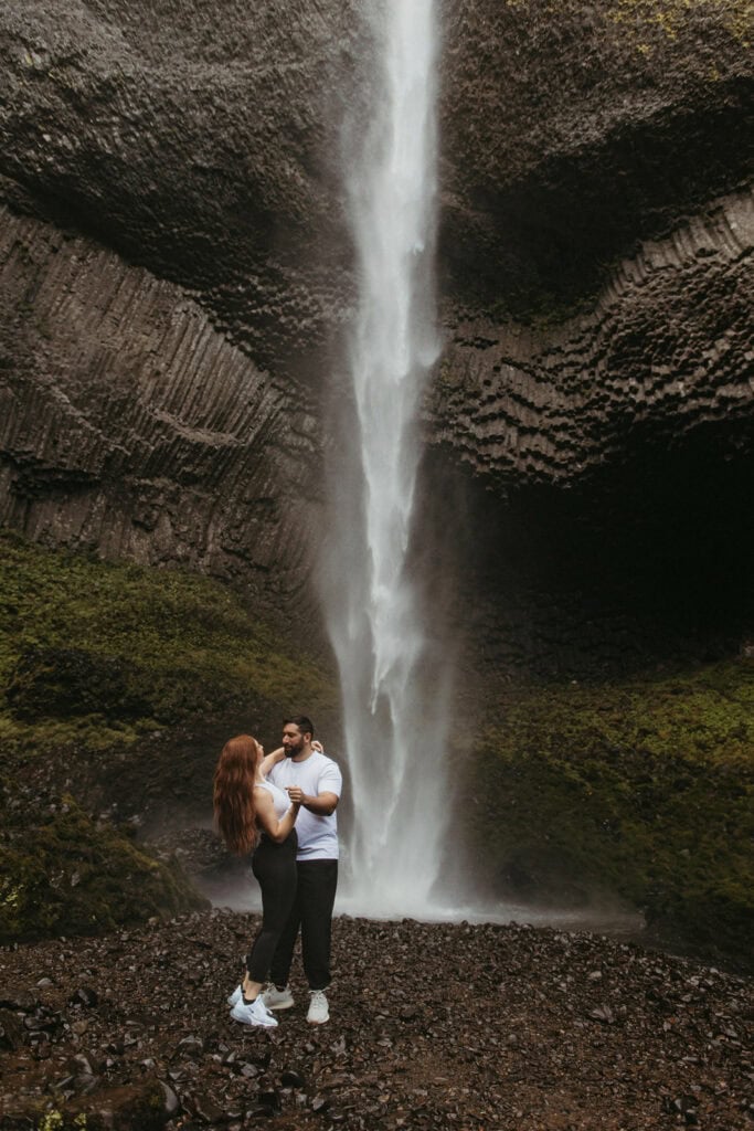 Adventurous engagement session at the base of a PNW waterfall